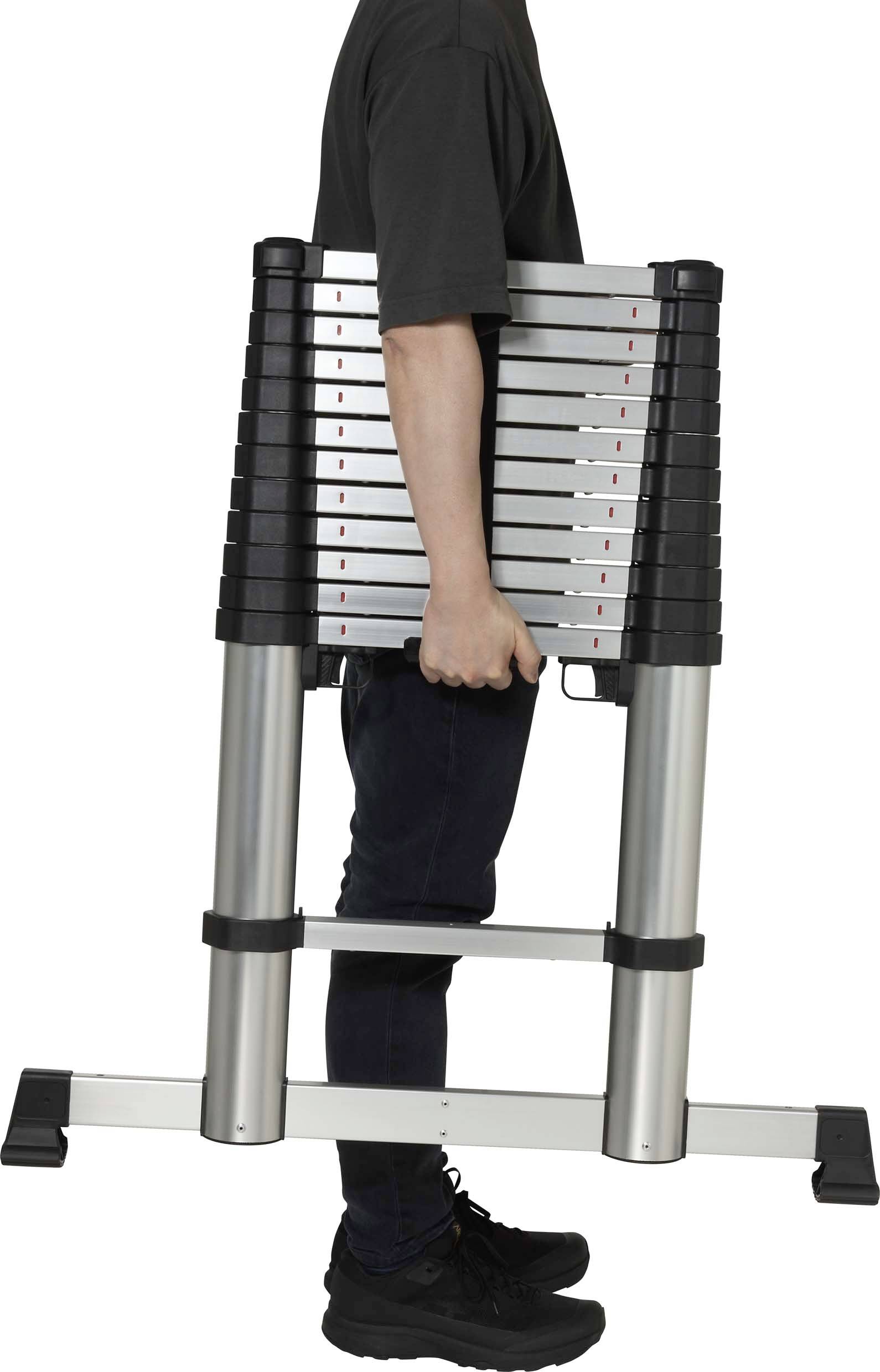 A person is carrying a folded, extendable aluminium ladder that is compact and portable. The ladder has black plastic details.