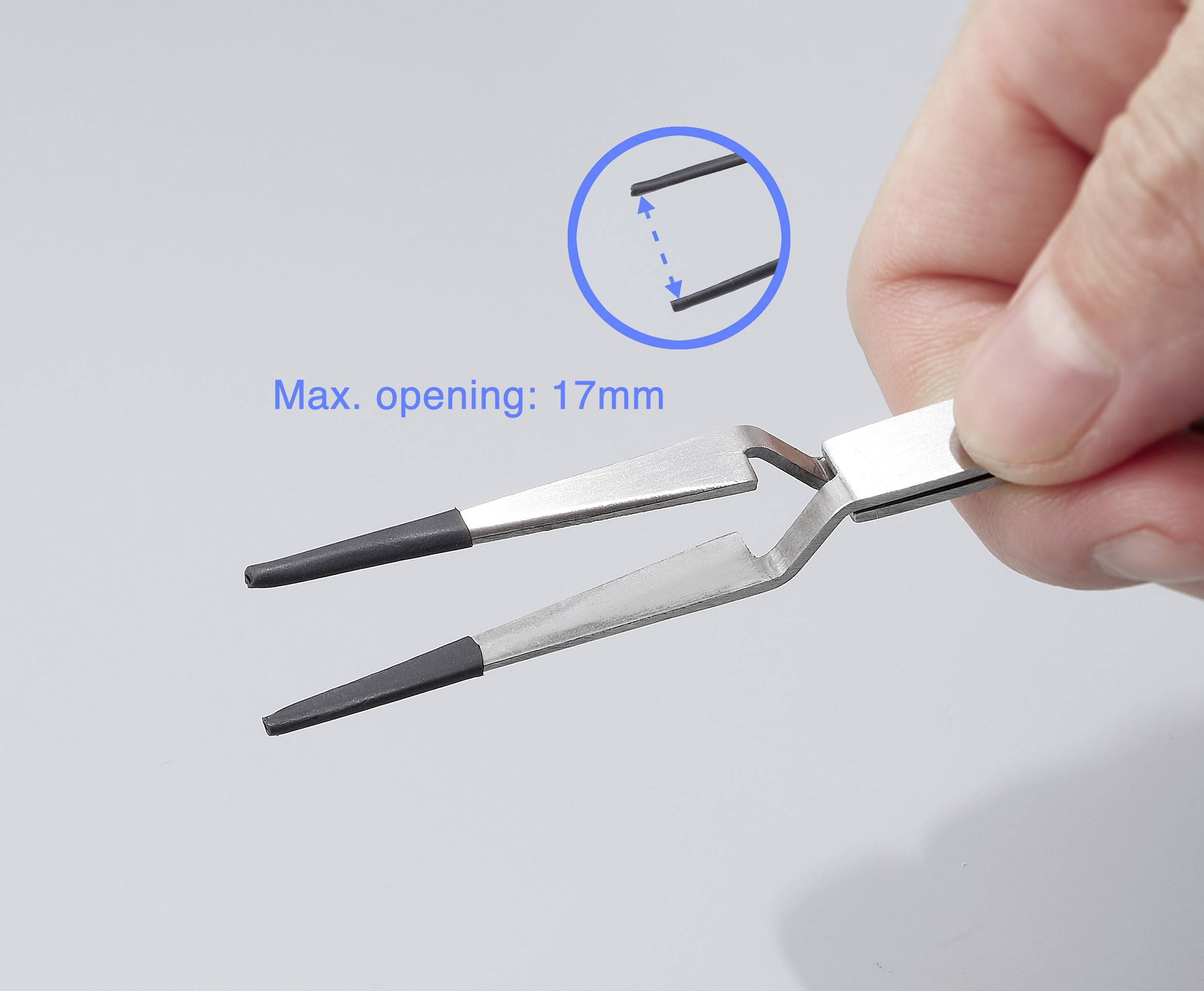A hand holds a pair of tweezers with two arms. The maximum opening angle is 17 mm. A circular zoom shows the tip connection.