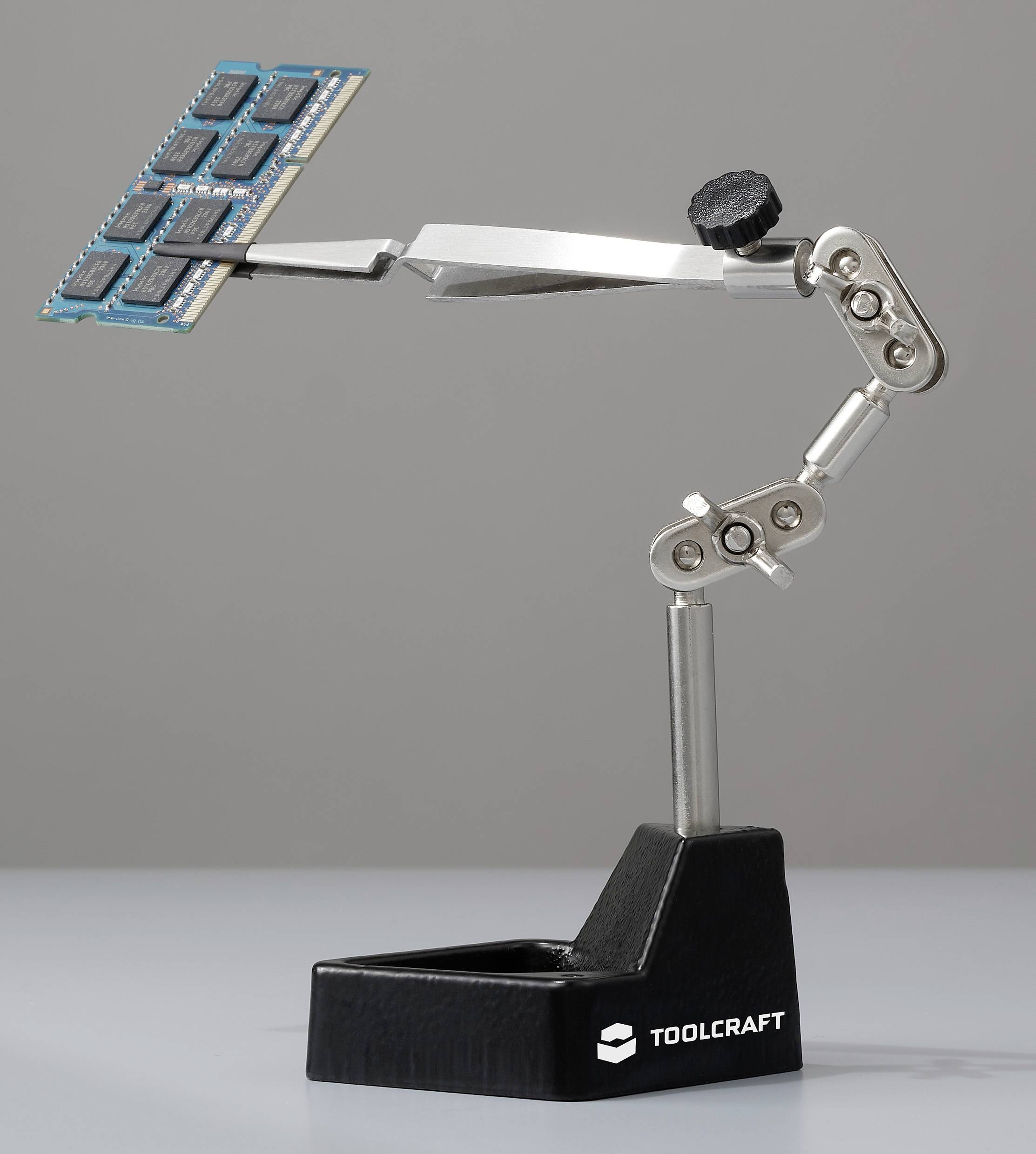 A soldering aid tool from TOOLCRAFT holds a series of memory chips in a movable gripper arm. Ideal for precise electronic work.