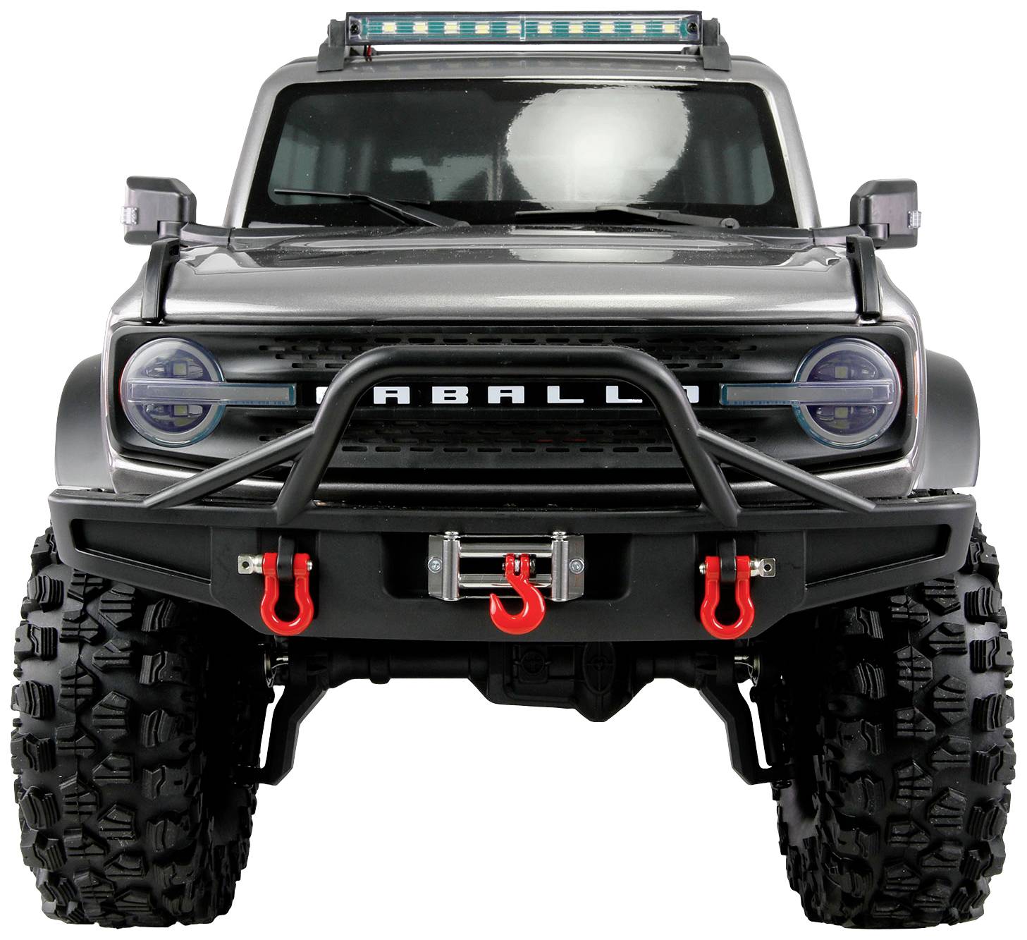 Off-road vehicle viewed from the front in close-up, featuring robust tyres, bumper and winch. A covered LED light bar is visible in the background.