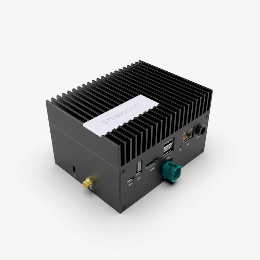 A small, black electronic device with multiple ports and heat sinks on the top surface, marked with 'STEREO RIGS'.