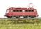 Red electric locomotive on track, side view, against a green meadow landscape. Locomotive number visible.