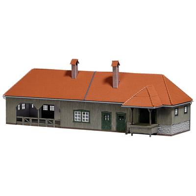 A model building with timber cladding and a red tiled roof. It has two chimneys and a covered entrance area.