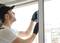 A tradesman is measuring the angle of a window with a digital device to ensure correct alignment.