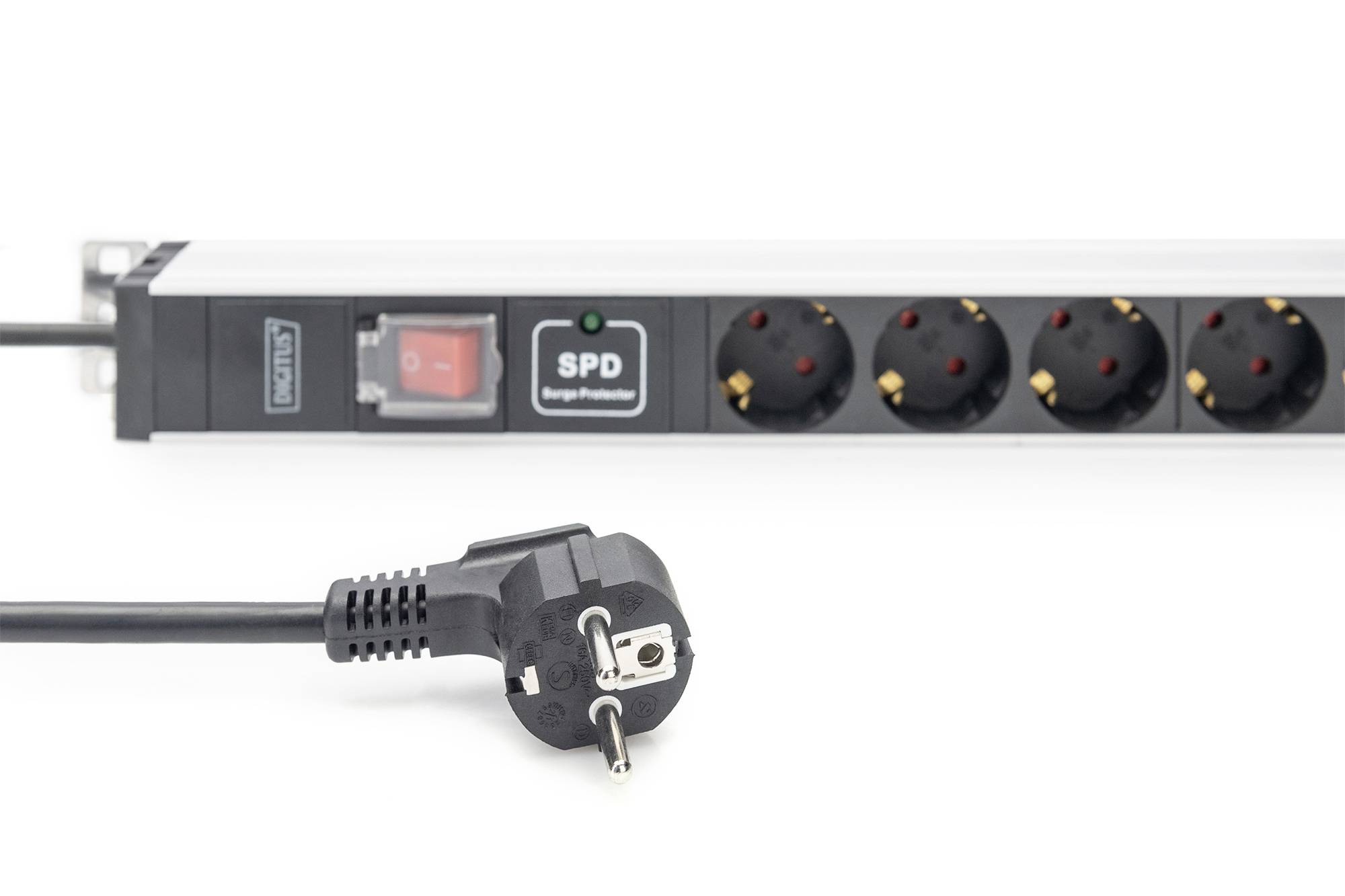 Multi-socket extension with surge protection, switch and five socket outlets. A plug is lying in front of it.