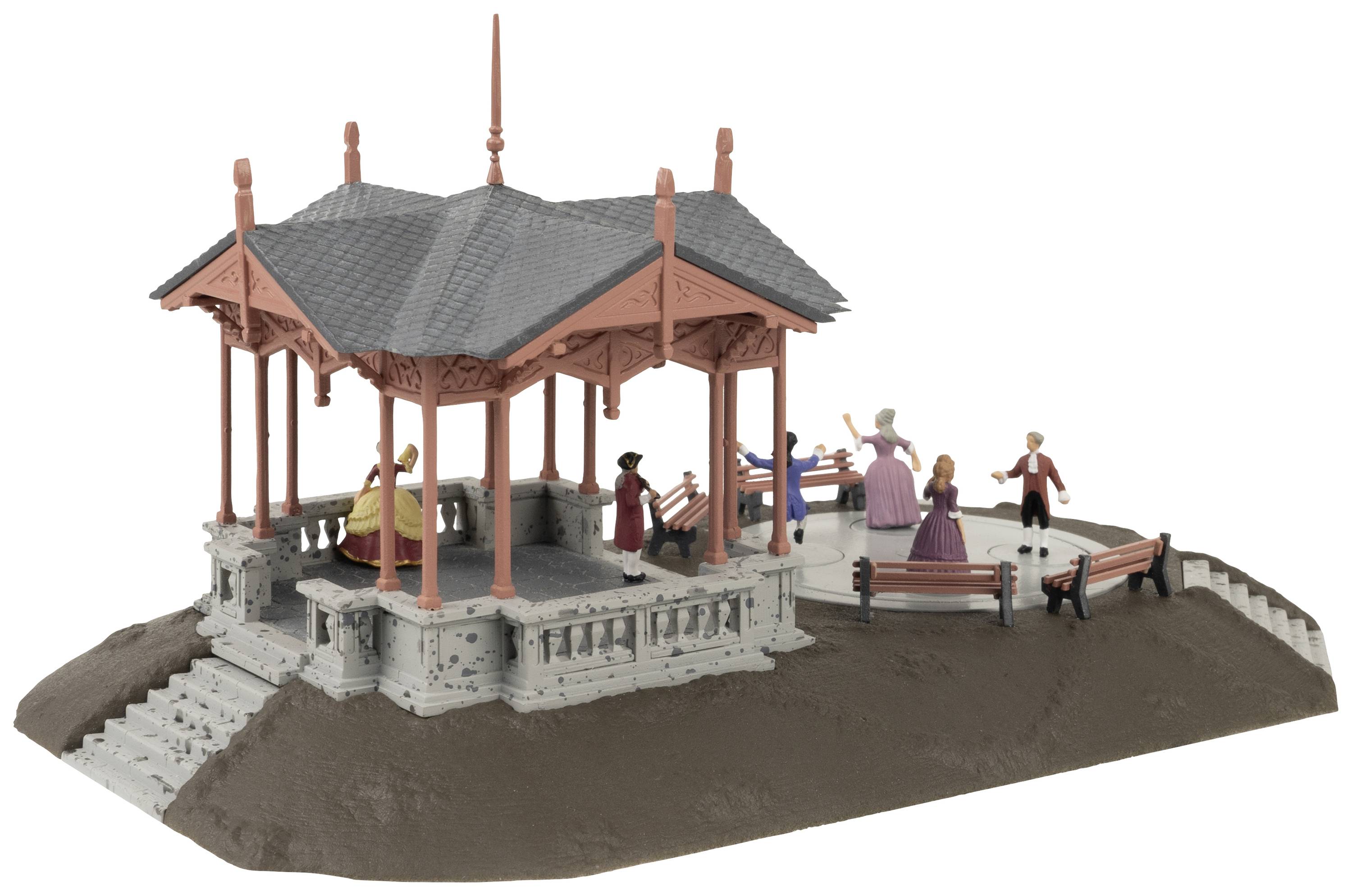 A miniature pavilion with figures seated on benches and children playing. A lady wearing a hat is standing, conversing with another gentleman.
