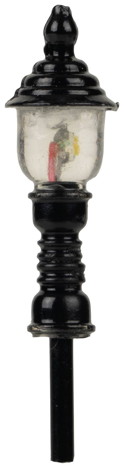 An old, black street lamp with a clear glass lampshade and intricate ornamental details.