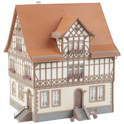 Half-timbered house model with flowers at windows, tiled roof and entrances. Architecture in traditional style, elaborately designed.