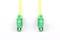 Two green fibre-optic connectors with yellow cables on a white background. They are positioned parallel and symmetrically.