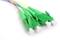 Four green fibre optic cable plugs, lying side by side, with coloured cables. They are ready for connection and data transmission.