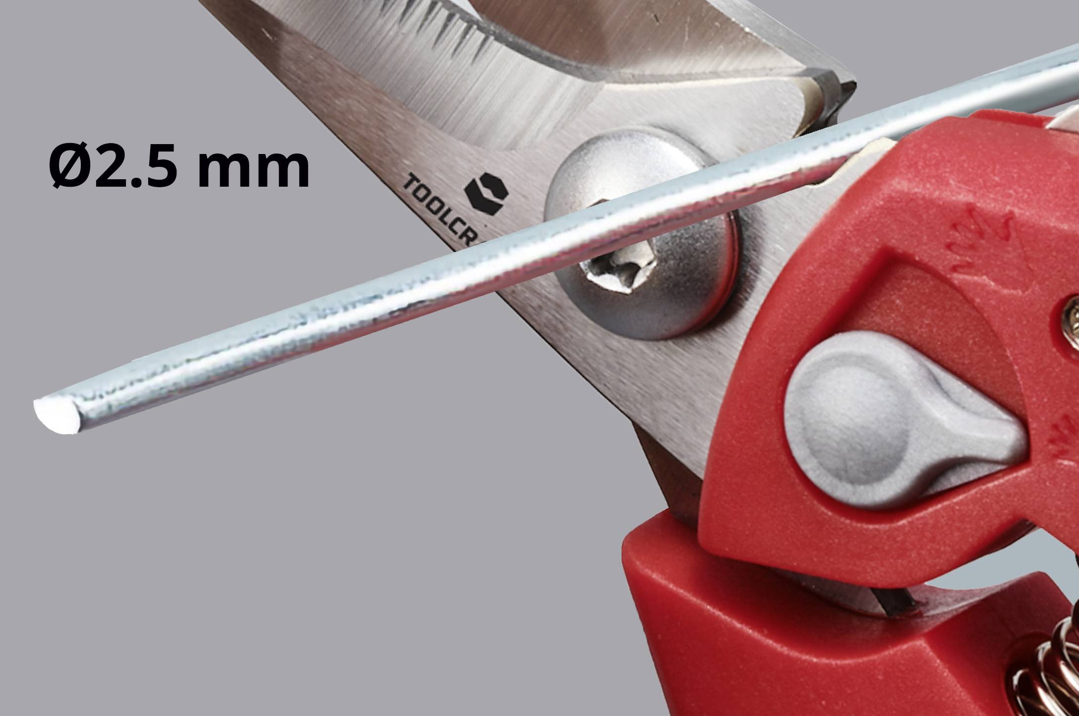 Scissors cutting wire with a diameter of 2.5 mm. Red handles, wire cutters in action.