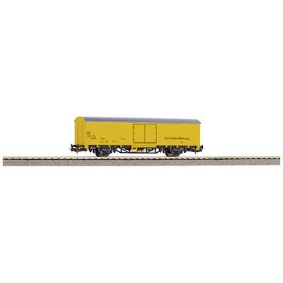 Yellow goods wagon on railway track, side view. Model of the Deutsche Bundespost with inscription 'Not within standard clearance profile'.