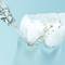 A close-up shows a water jet cleaning interdental spaces and removing food debris, against a blue background.