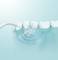 'Close-up of a water flosser spraying a water jet for cleaning between teeth, shown against a light, aqua-coloured background.'