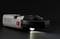 A grey Voltcraft voltmeter on a dark background, with an illuminated torch at the bottom edge.