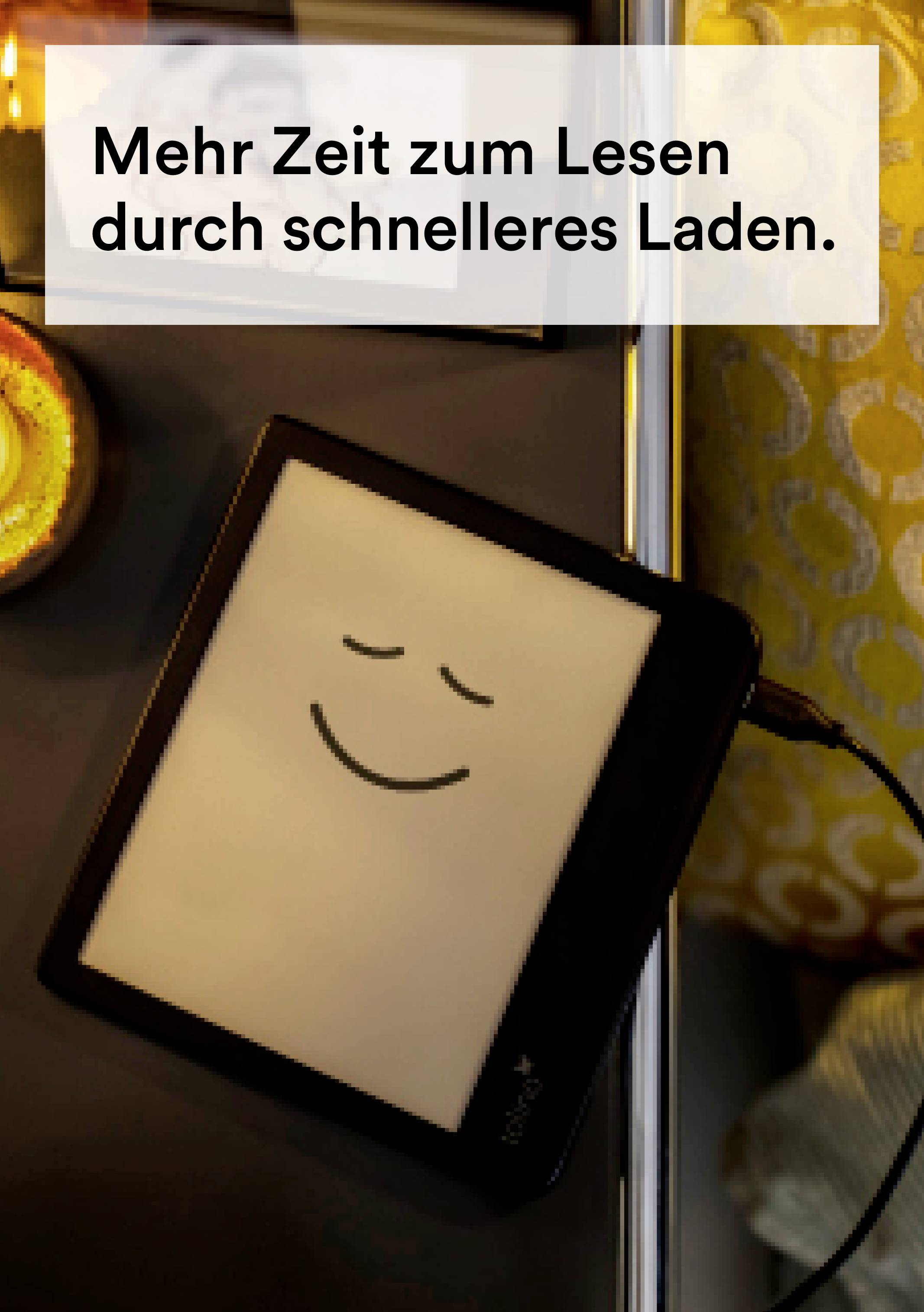 An e-reader is lying on a table next to a candle and a cushion. A smiling face is displayed on the screen. Text: 'More time for reading through faster loading.'