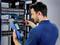 A technician is testing cable connections in a server room with a measuring device to carry out network improvements and troubleshooting.