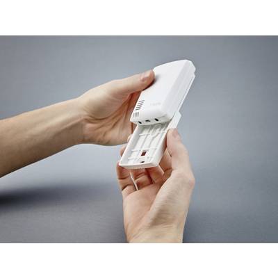A person is holding an open Wi-Fi router in their hands, revealing its internal components. The background is grey.