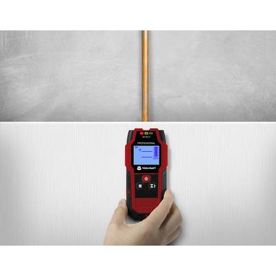 A tradesperson is using an electronic detection device on a wall to locate the position of a copper pipe.