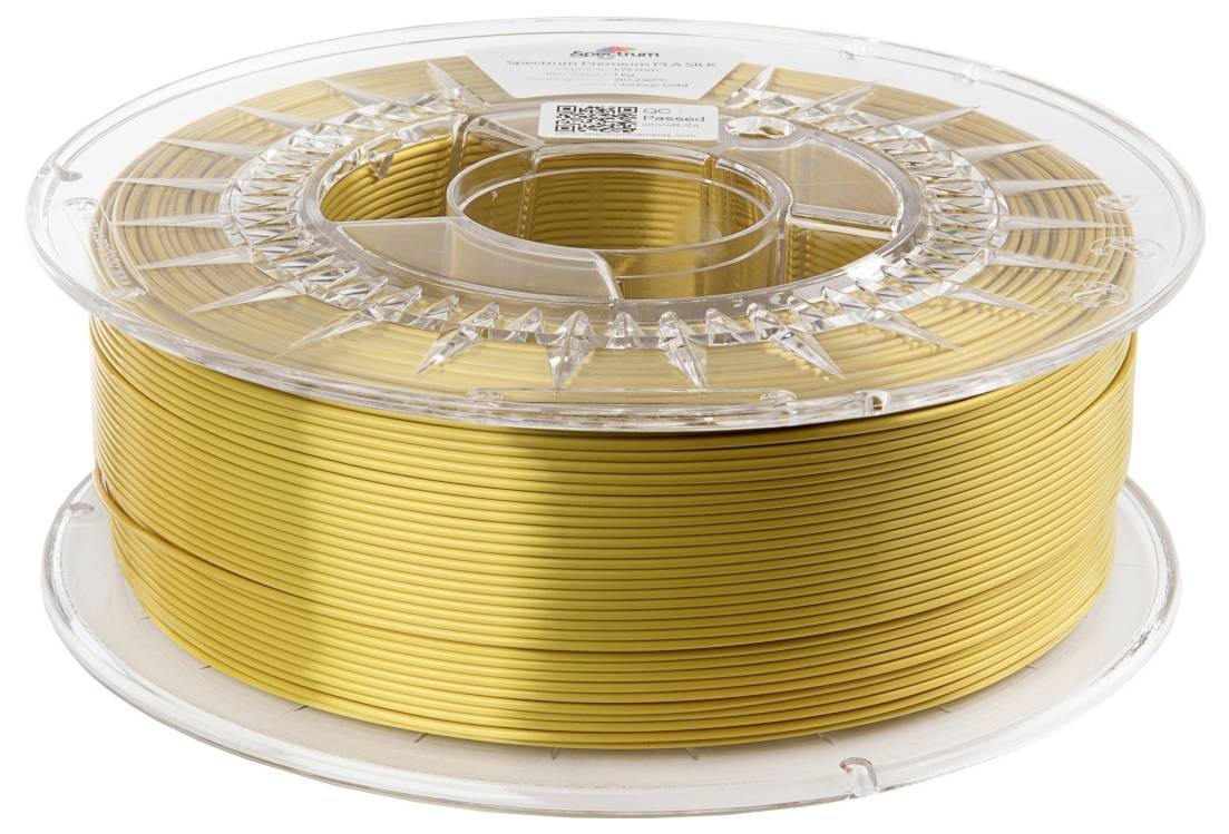 Gold-coloured filament spool with 3D printing material, in a transparent plastic packaging.