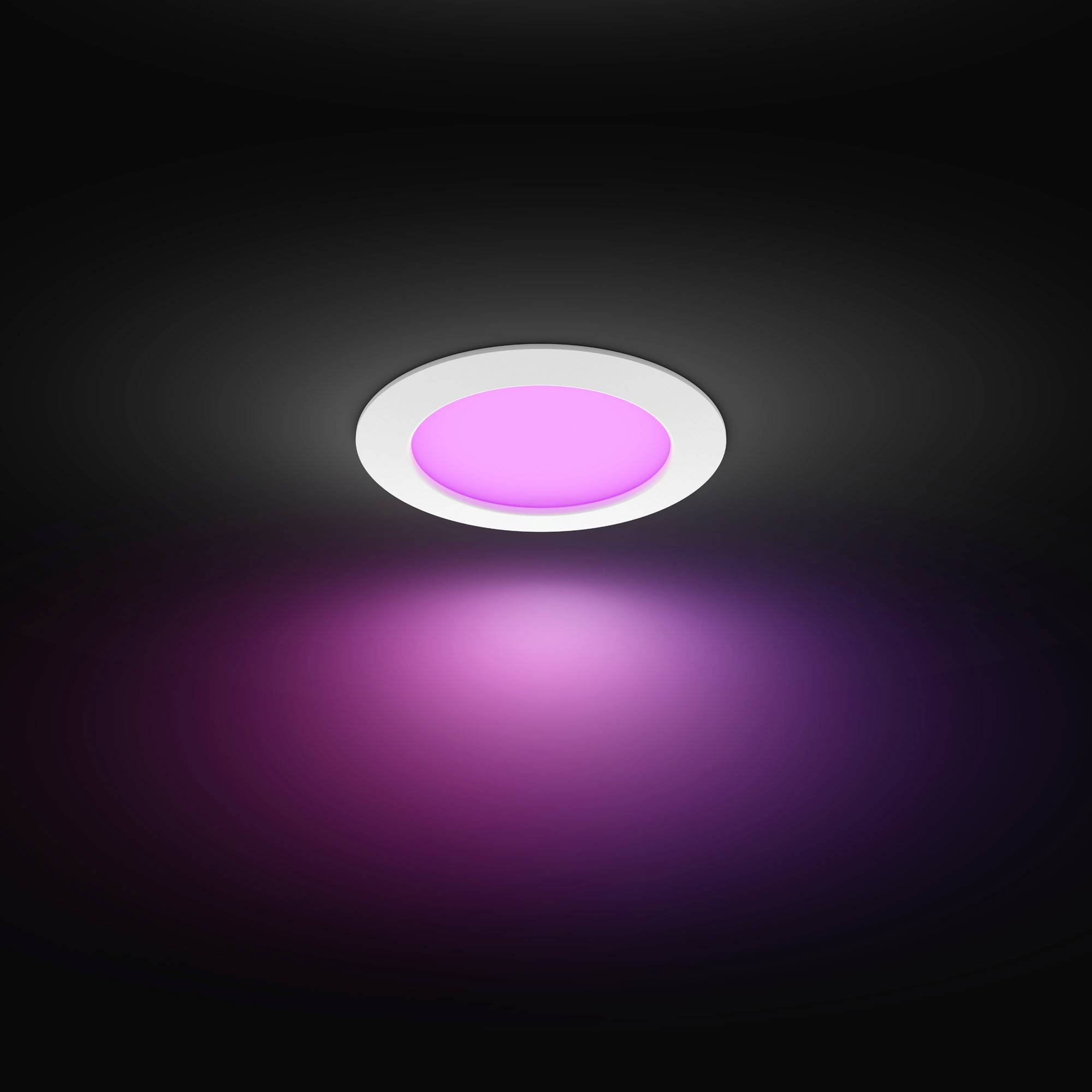 A round LED light emits purple light, built into a dark ceiling, creating a moody atmosphere.