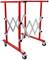 Red, height-adjustable roller stand with four wheels and grey zigzag mechanism, suitable for workshop use.