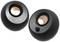 Two spherical speakers with a black housing and copper-coloured membranes. One speaker has a volume control dial.