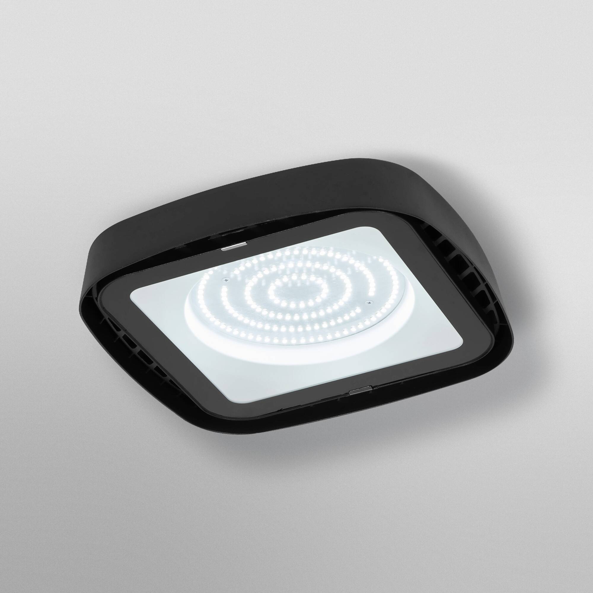 A modern, square LED ceiling panel with a black frame and bright, spiral illumination pattern.