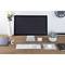 A tidy desk with a large monitor, keyboard, mouse and plants. The wall clock shows just after nine.