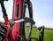 Red e-bike in a stand with an integrated bicycle lock, against a green lawn background under a blue sky.