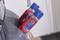 Two spray cans in red holders are positioned on the edge of a blue object. They are located in an interior space.