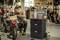 A man is repairing a motorbike in a workshop. Next to him is an open toolbox and a bottle of oil.