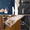 A person is holding an ID card with a keyring attached to their clothing. Another bunch of keys is hanging from a trouser pocket. A hand is inserting keys into a door lock.