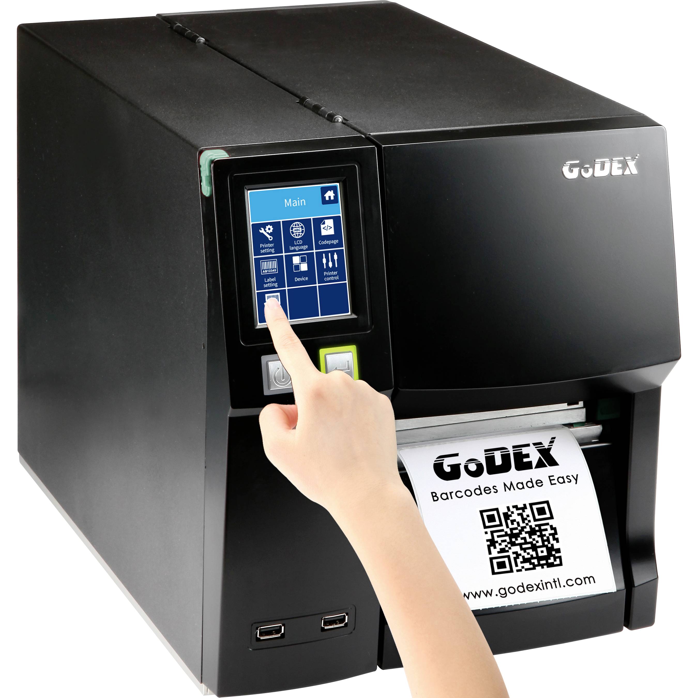 A label printer producing a barcode label. A hand is operating the touchscreen with menu options. Text on the label: 'GoDEX Barcodes Made Easy'.