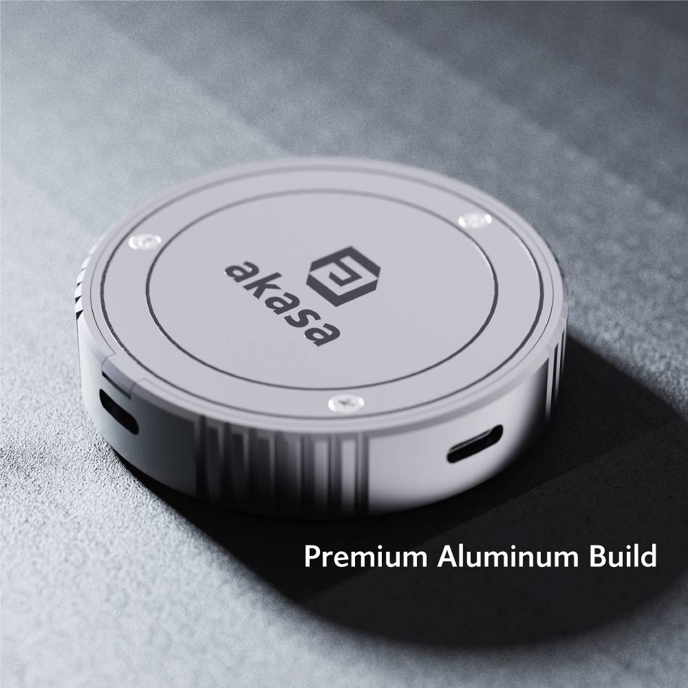 Round, grey device with 'akasa' written on the top surface, surrounded by light reflections. Text alongside: 'Premium Aluminium Construction'.