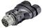 A black, multi-shaped adapter with several connection pins, likely for electrical or electronic connections.