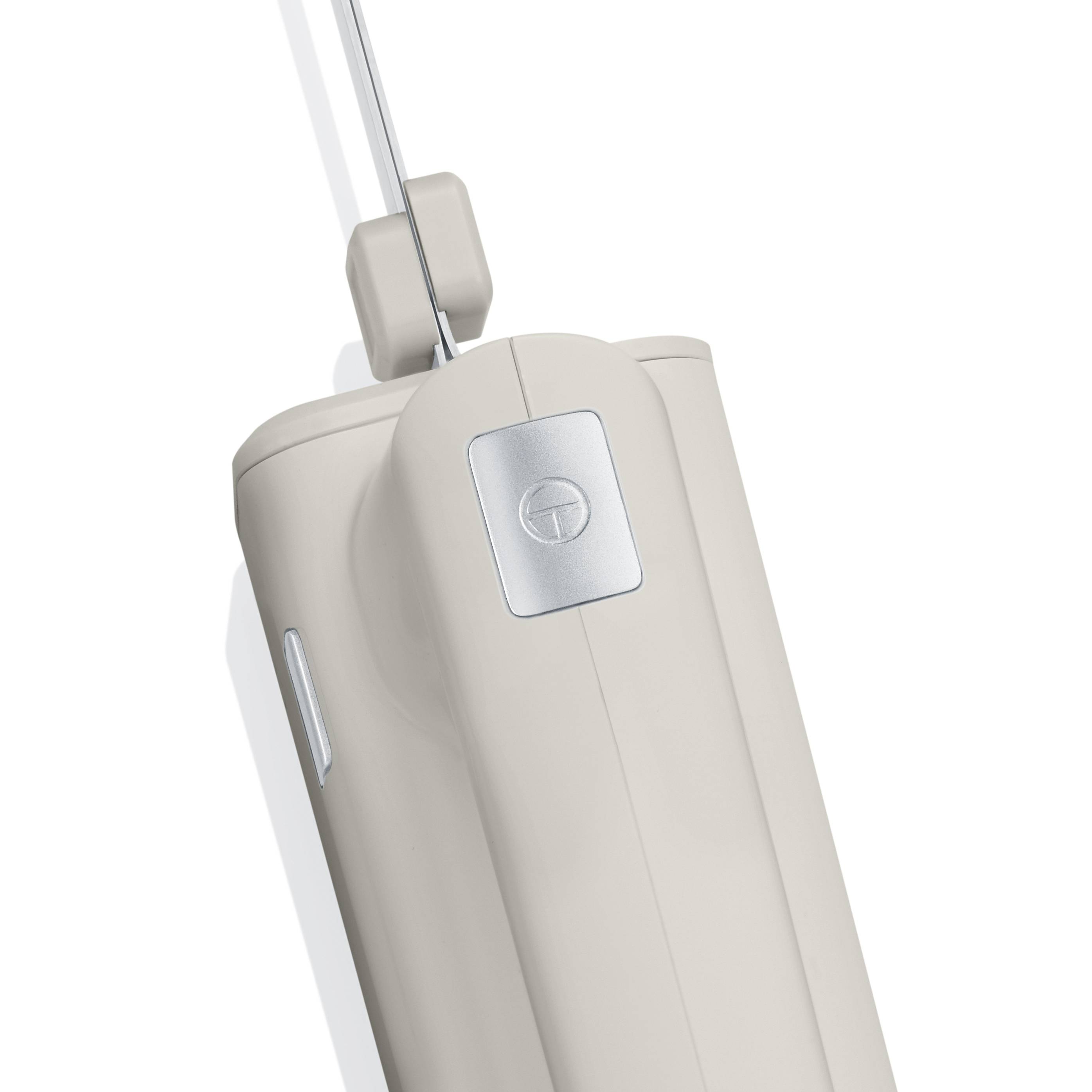 A white, cordless hand mixer with a handle and detachable, chrome-plated beaters.