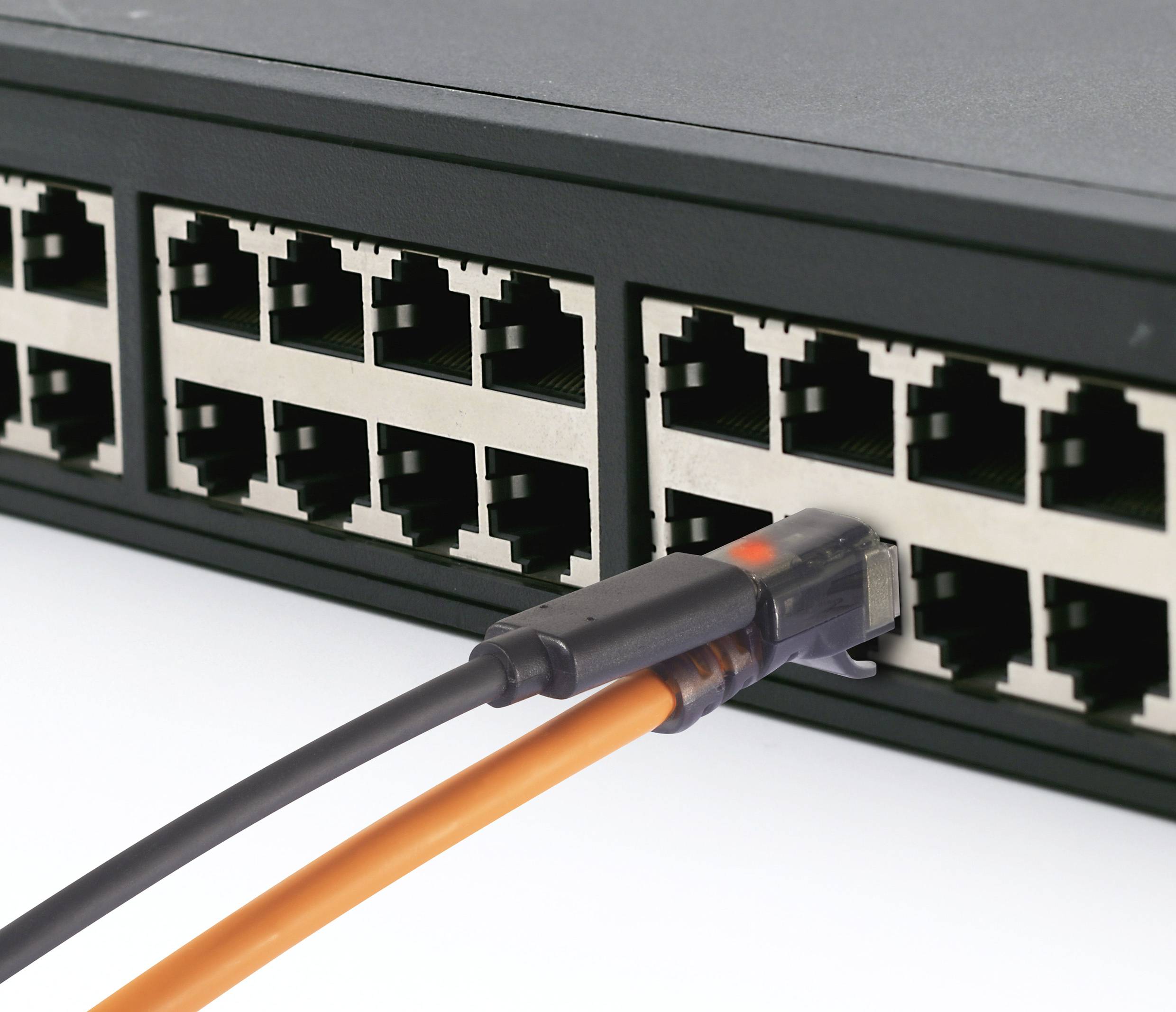 A black network switch with an orange Ethernet cable plugged into one of its ports.