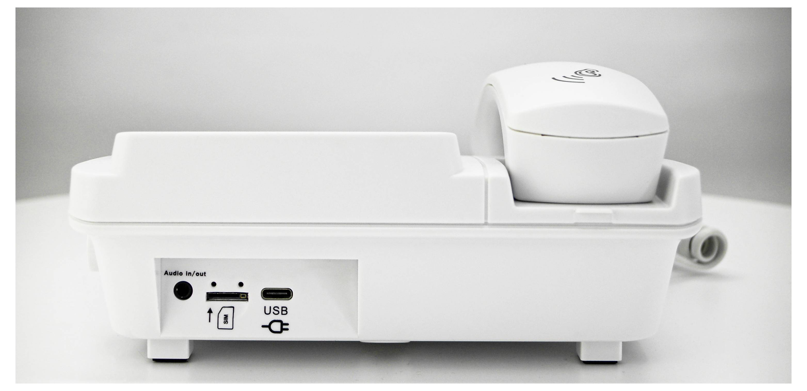 A white, modern device with a headphone on the top surface. On the front, there are sockets for audio and USB.