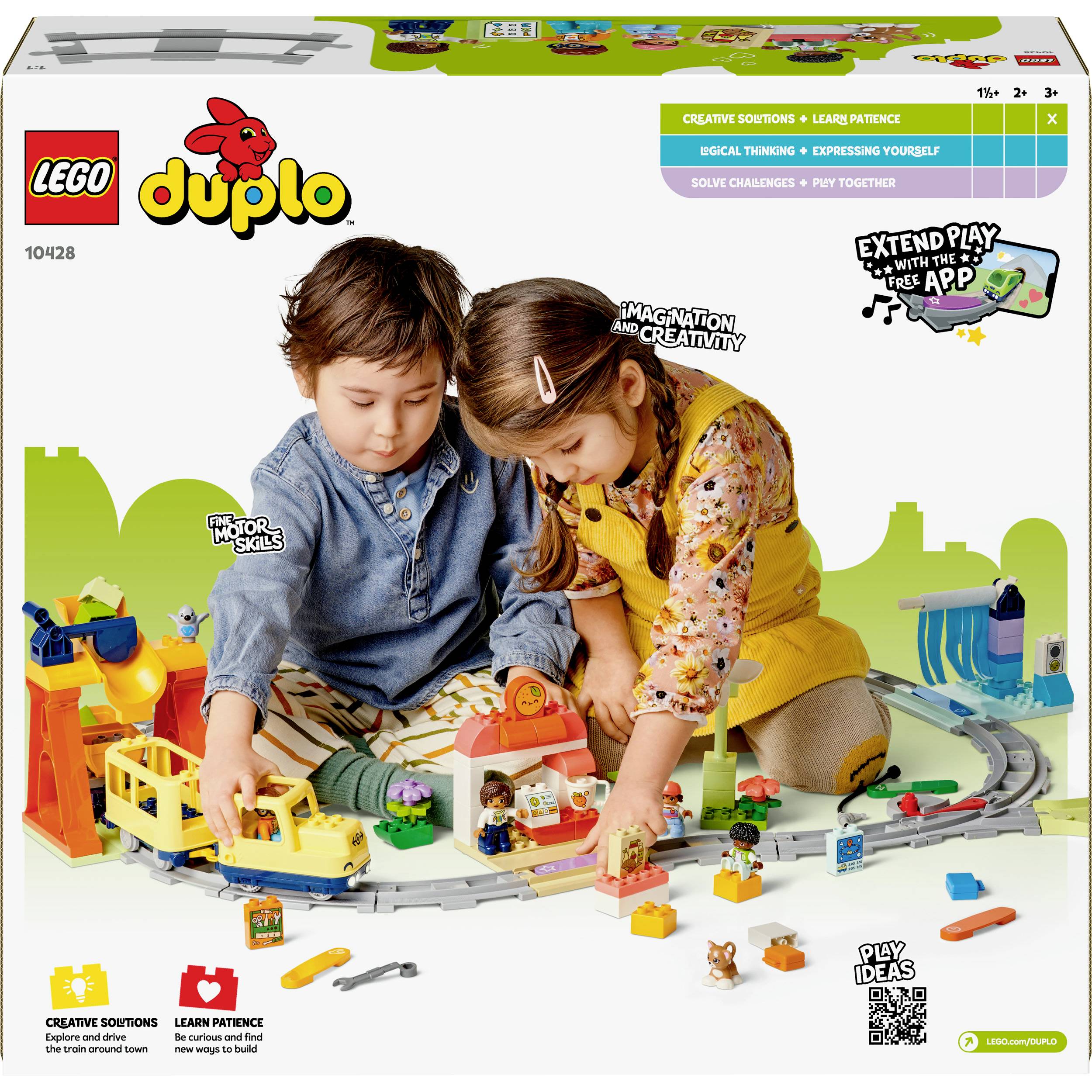 Children are playing with a LEGO DUPLO train set on a white background. Various colourful pieces and toys are scattered on the floor.