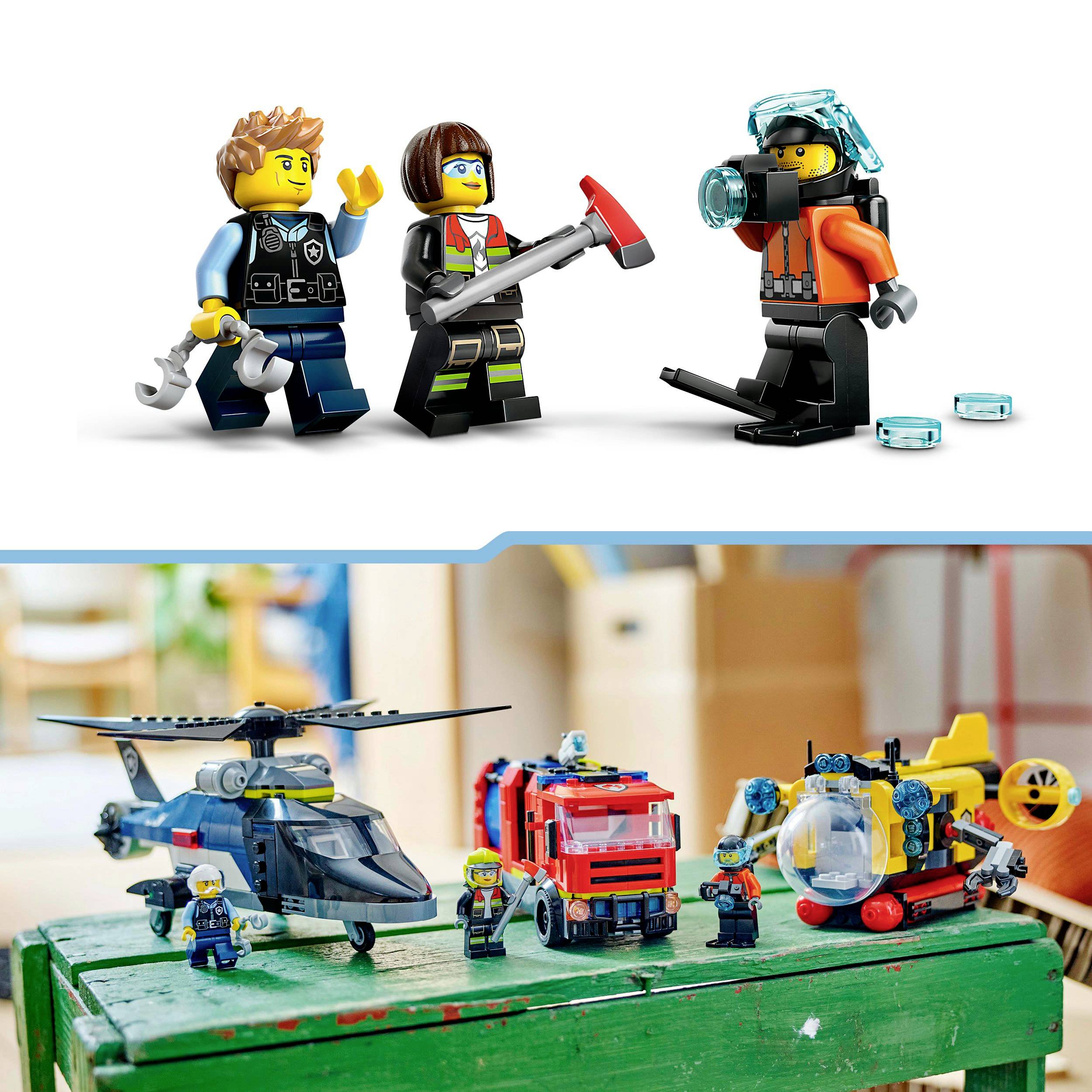 Three Lego figures in police and firefighter uniforms stand next to a craft table. On the table are toy helicopters, a fire engine, and additional figures.