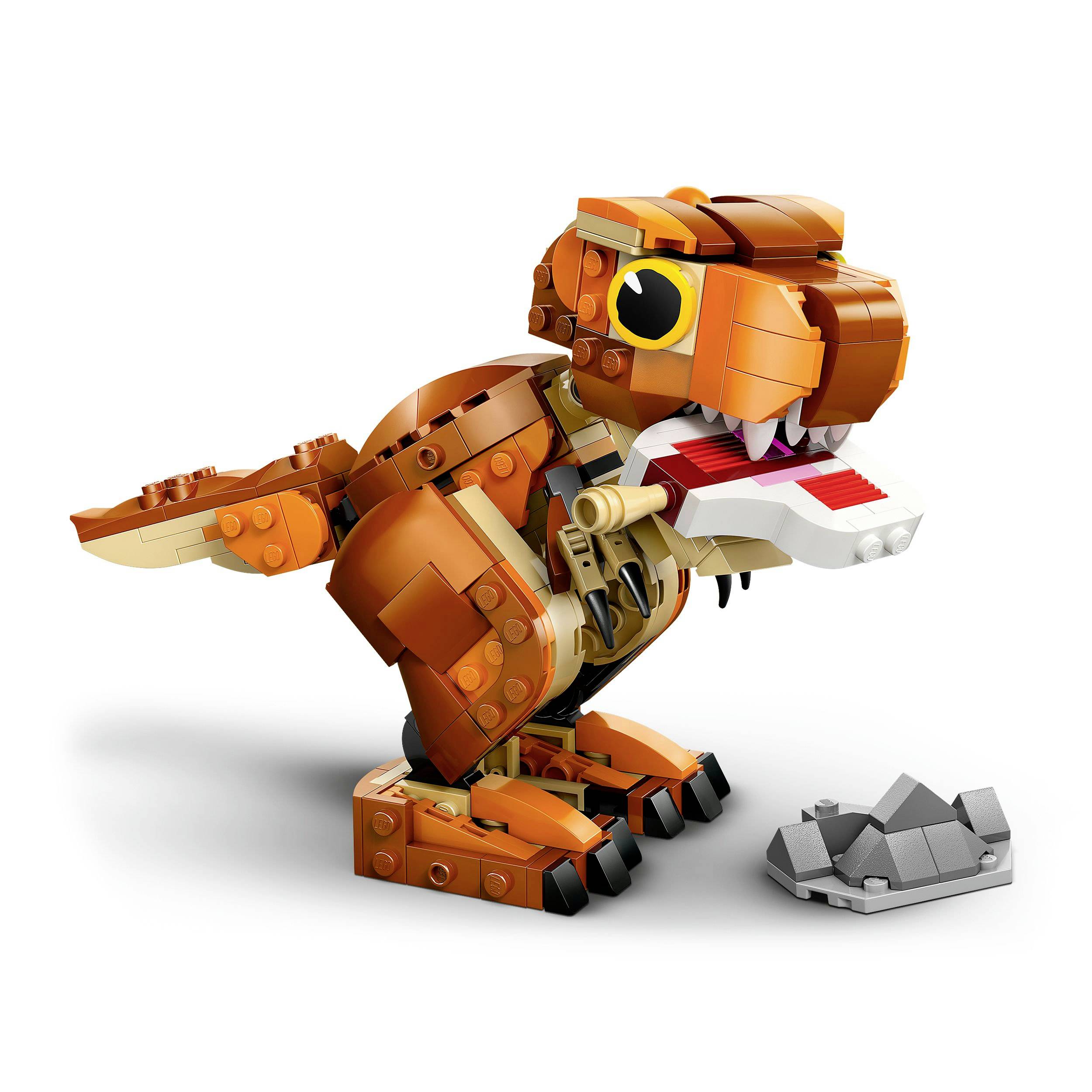 An orange-brown dinosaur model made of building blocks with a movable tail and jaw stands next to a grey rock block.