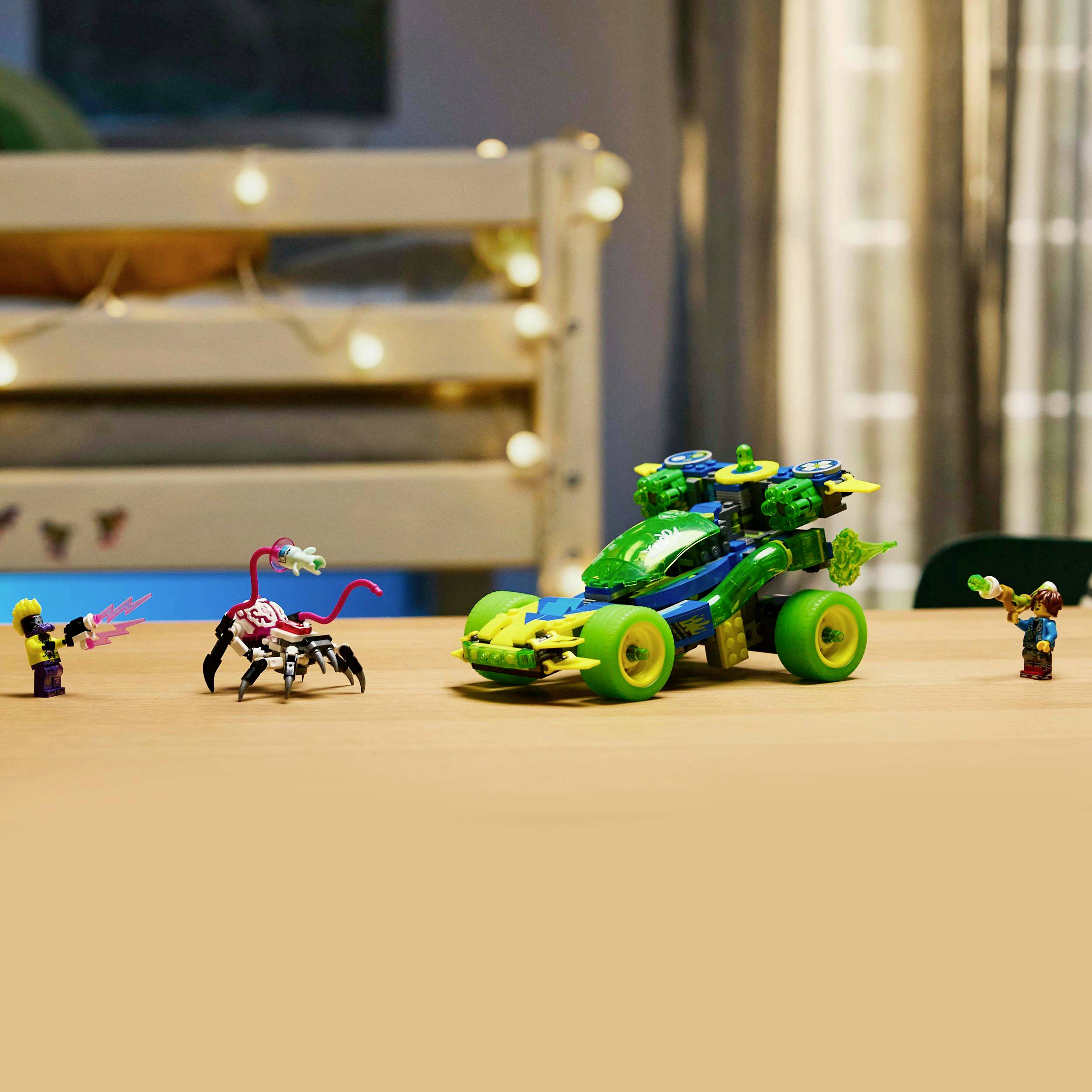 A Lego car with green accents and a crab Lego toy are sitting on a table, surrounded by Lego figures interacting with each other.