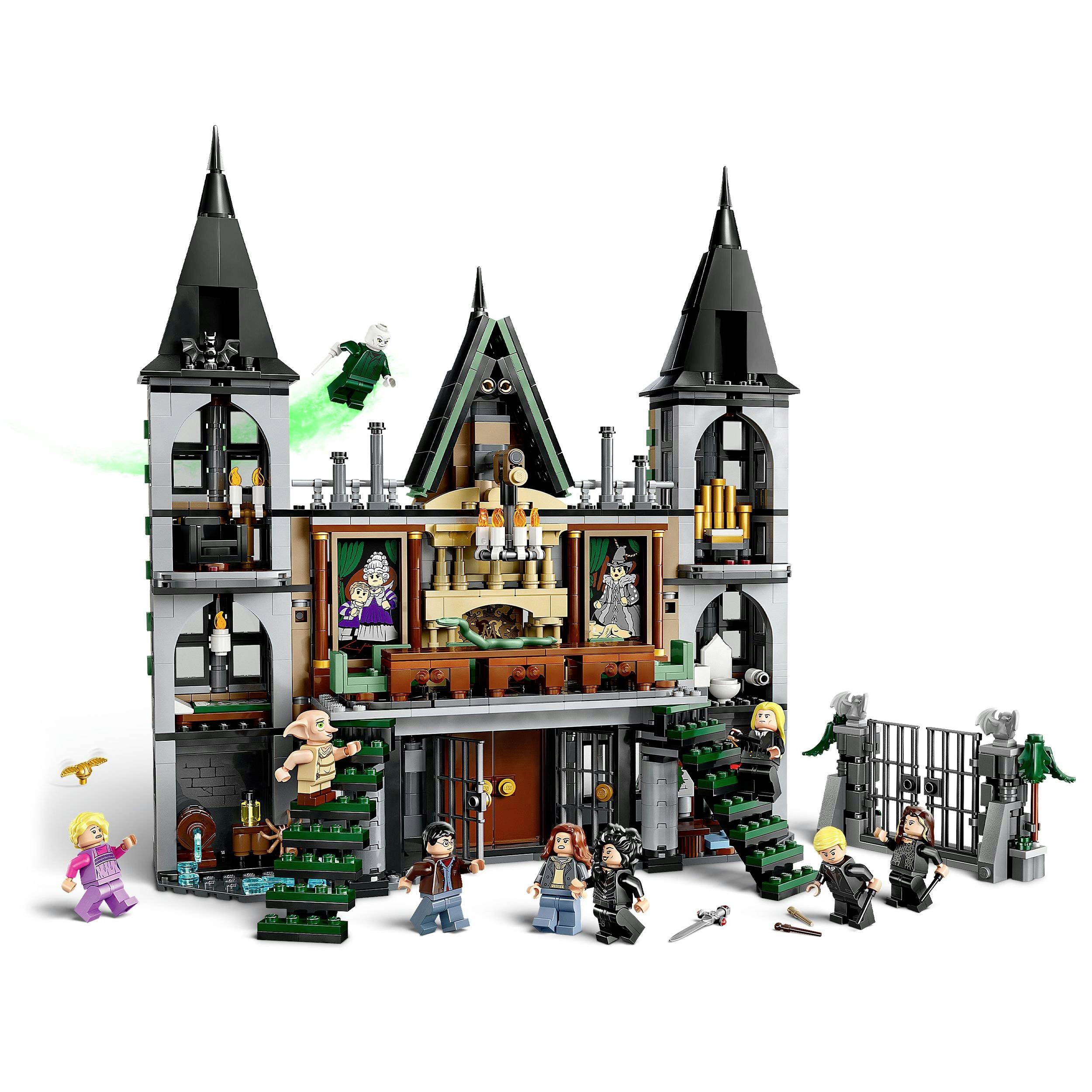 A detailed, multi-storey toy castle with figures on staircases and in the courtyard, surrounded by a wall with a gate.