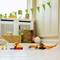 Toy robots and figurines on a wooden floor, colourful bunting in the background. Cosy, bright living space environment.