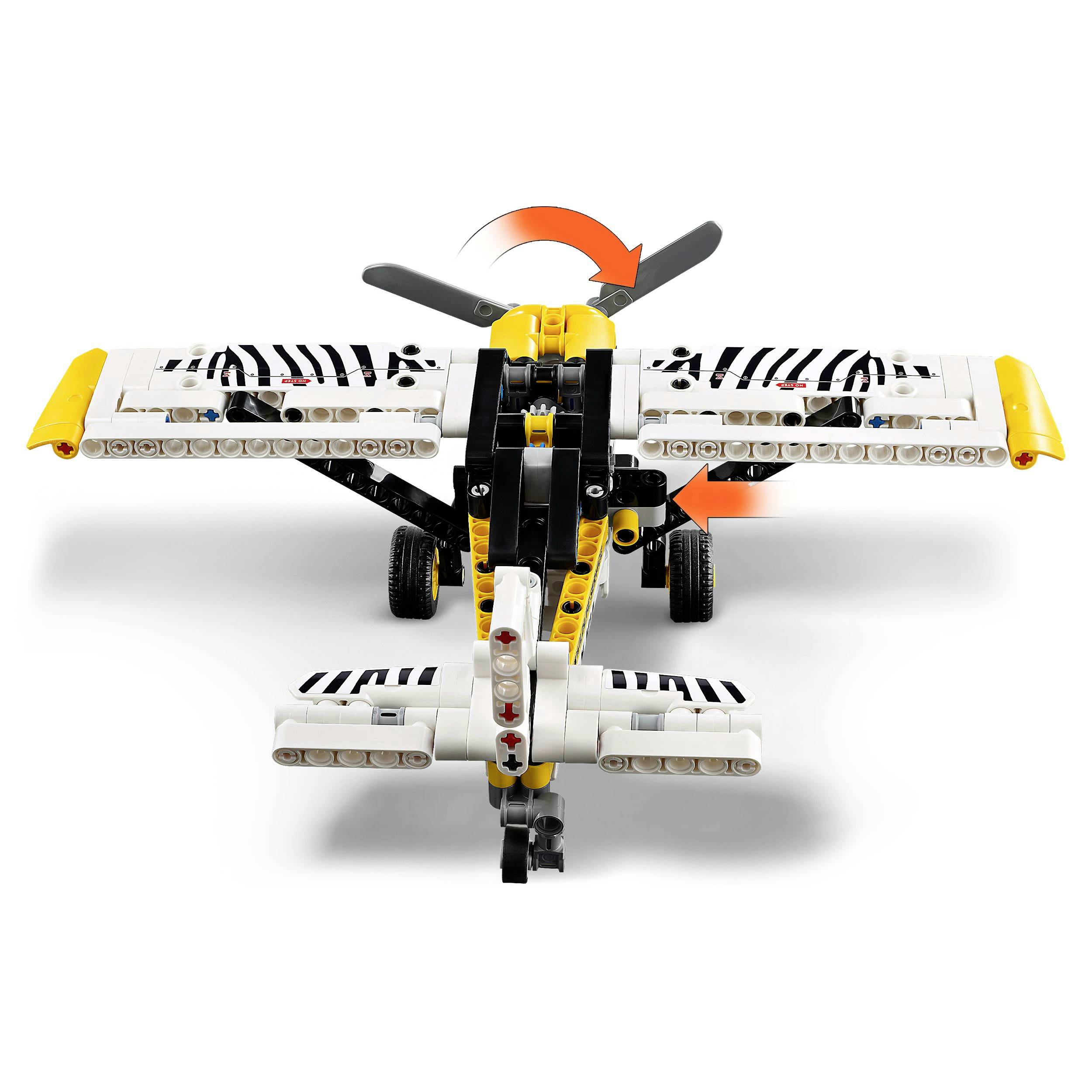 A model aeroplane made from building blocks in yellow, white, and black parts. The rotors and wings show movement arrows.