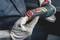 A worker wearing gloves is holding an electric angle grinder. The device has red and green markings.