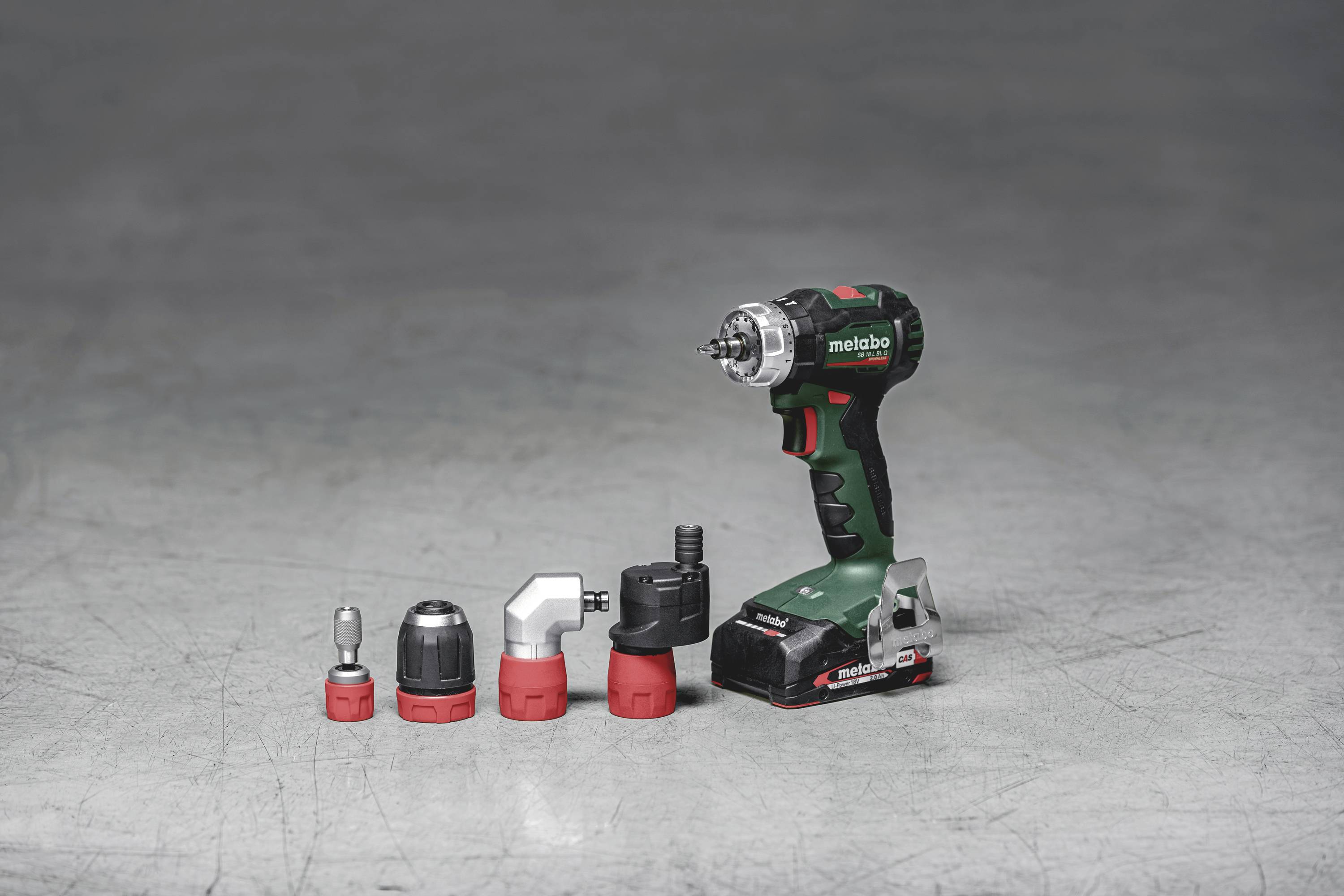 Cordless drill with five interchangeable drill heads on a grey background.