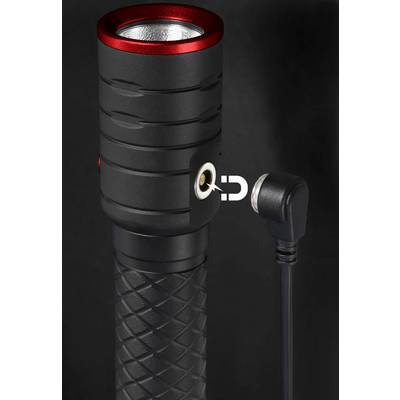 A black torch with a red border shows a side magnetic charging port, to which a charging cable is connected.