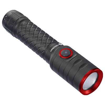 A black torch with a red border and switch, lies at an angle on a surface. It has an embossed, non-slip grip pattern.